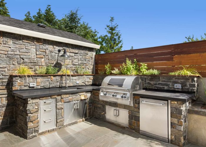 Backyard hardscape patio with outdoor barbecue and kitchen